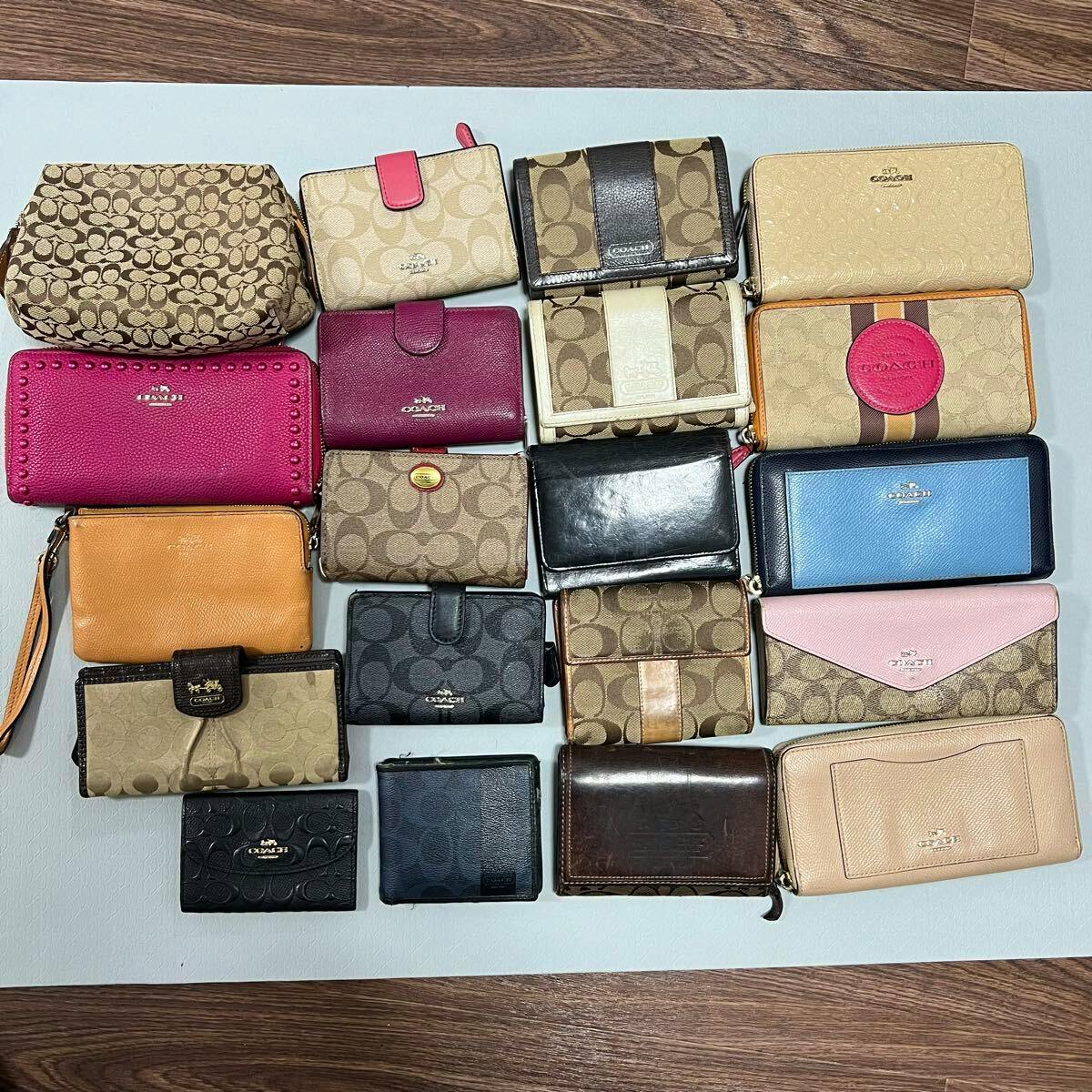 Multiple COACH wallets and small pouches arranged flat on a light background, showing various colors and signature patterns.