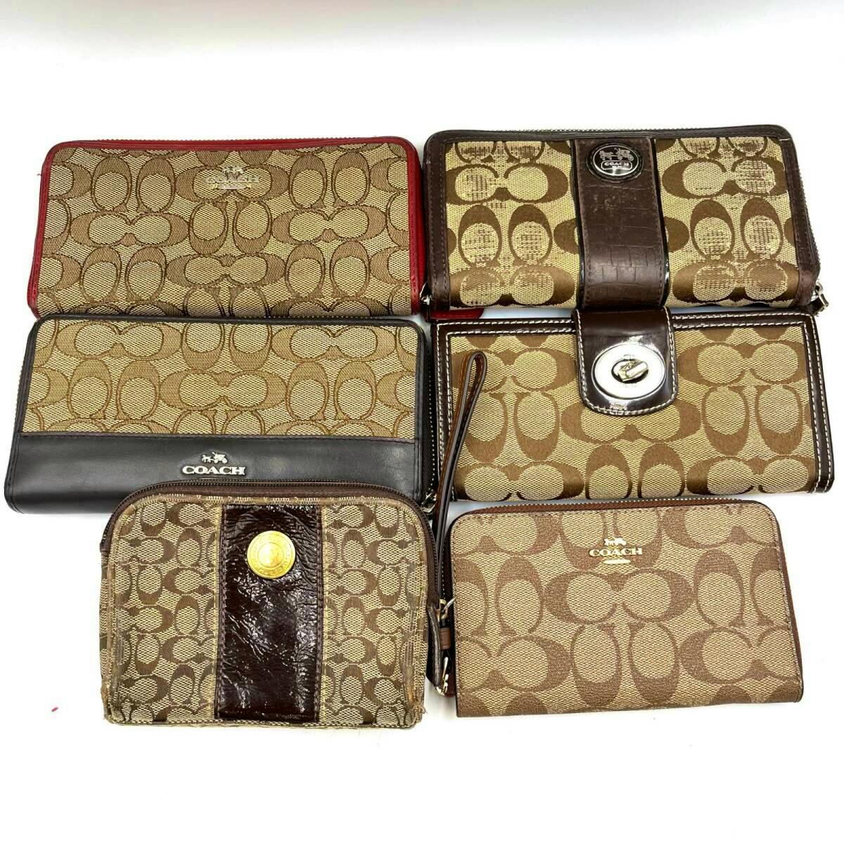 Six Coach wallets and pouches in signature 'C' monogram canvas and brown leather arranged on a white background.