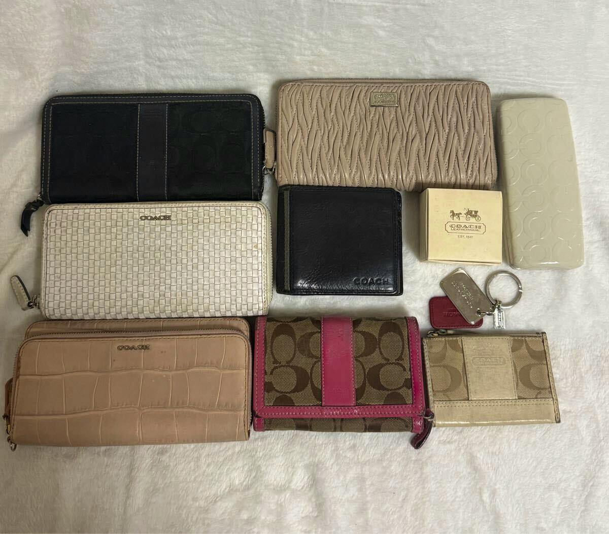 Several Coach wallets and small accessories from a 9-piece set arranged on a light background.