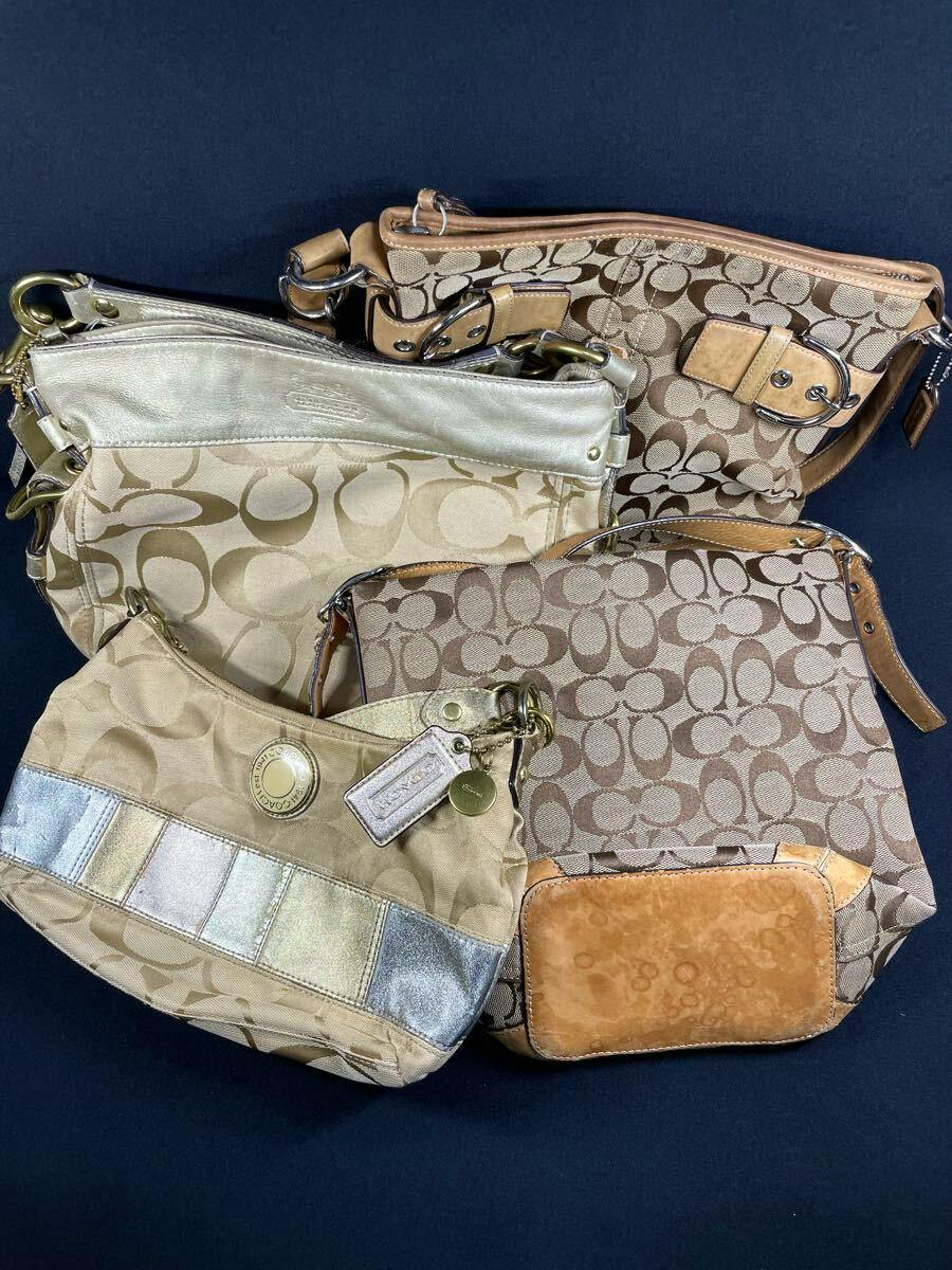 Four Coach shoulder bags in signature C canvas patterns with leather trim arranged on a dark background.