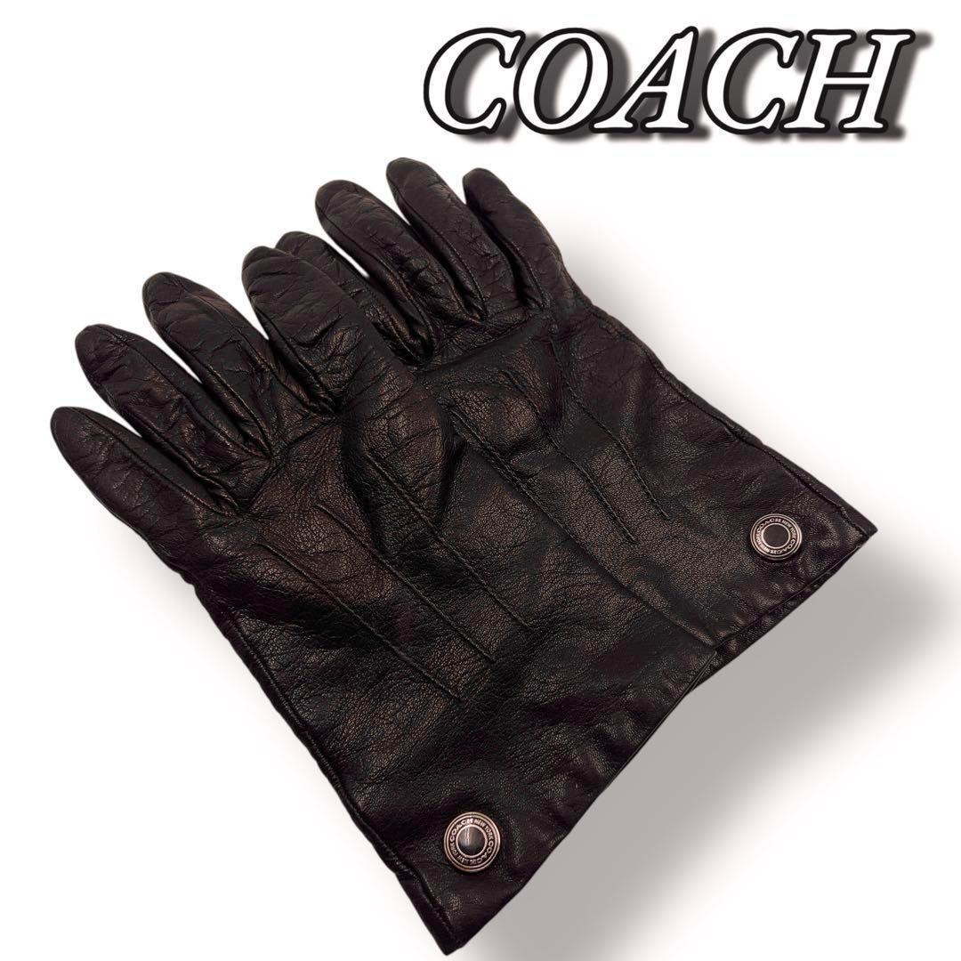 Pair of dark brown Coach women's cow leather gloves laid flat showing visible metal snap closures.