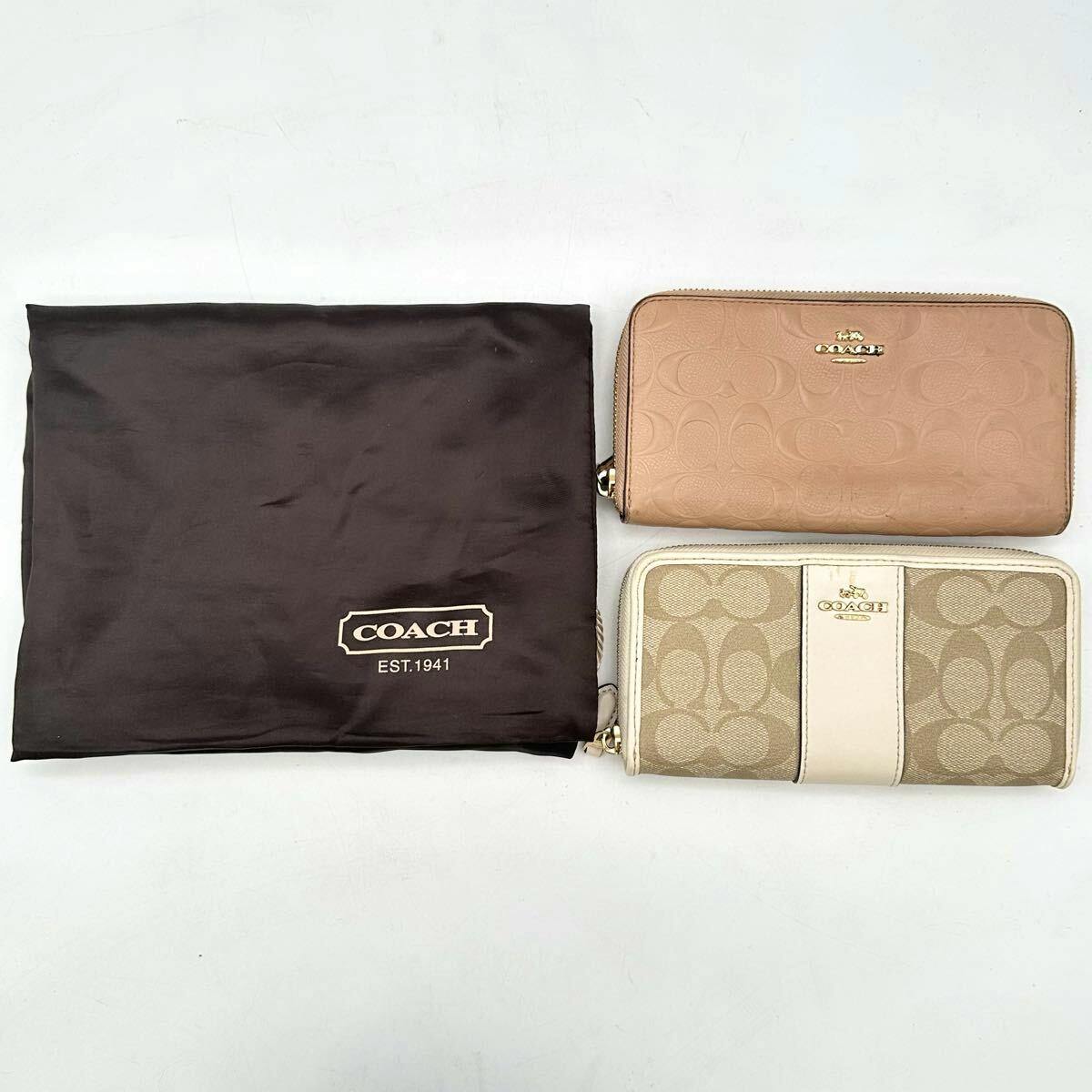 Two COACH long zip-around wallets displayed next to a COACH dust bag on a white background.