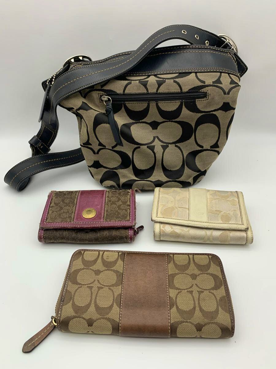 A Coach canvas shoulder bag with three matching Coach wallets arranged on a white background.