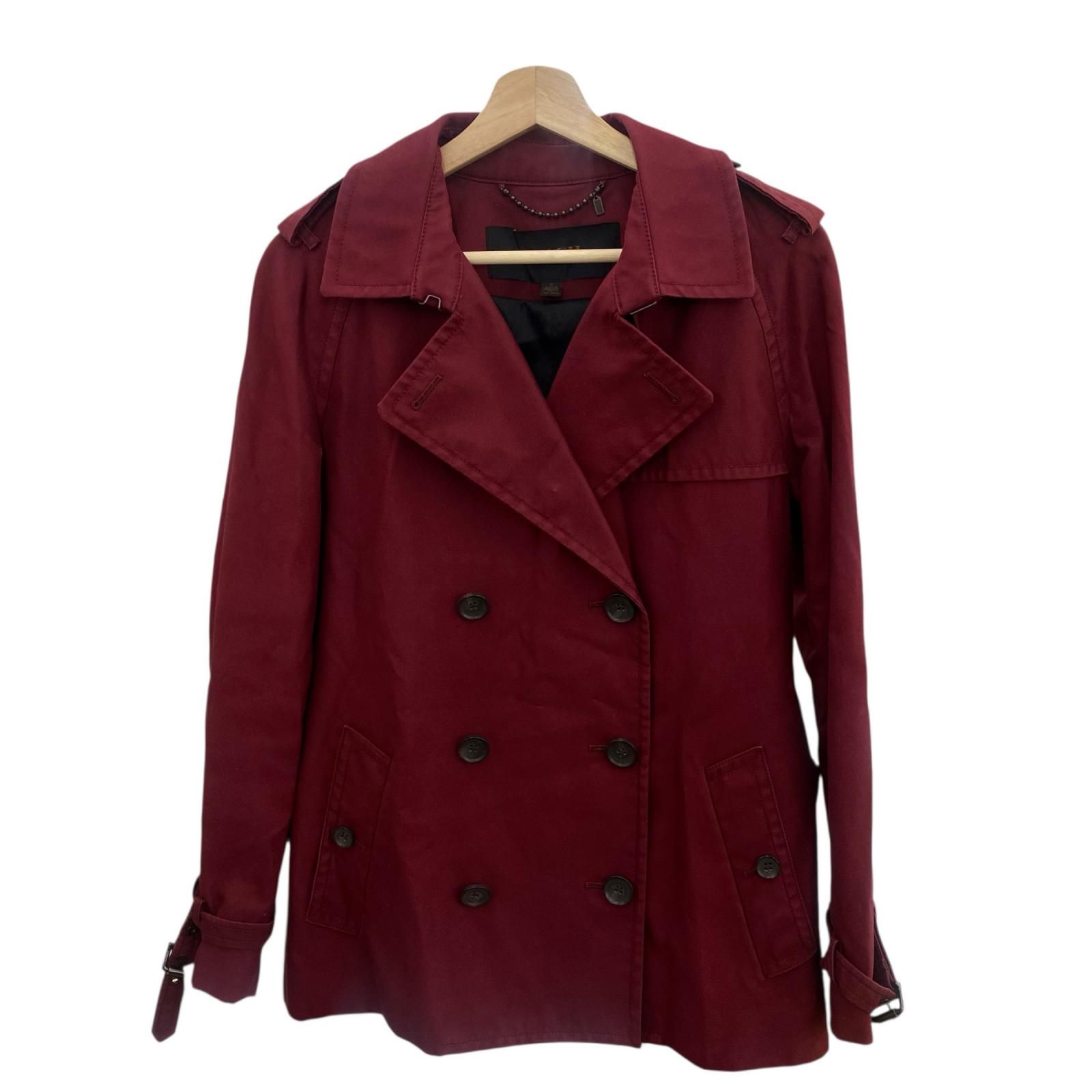 Front view of a women's wine-red COACH trench coat (cotton) size M hanging on a wooden hanger.