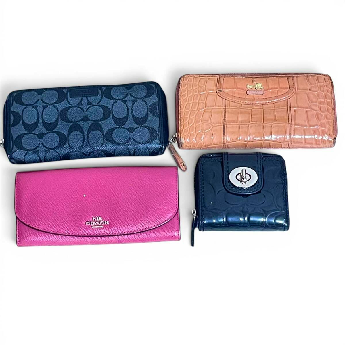 Four Coach women's wallets displayed flat on a white background, showing different colors and textures.