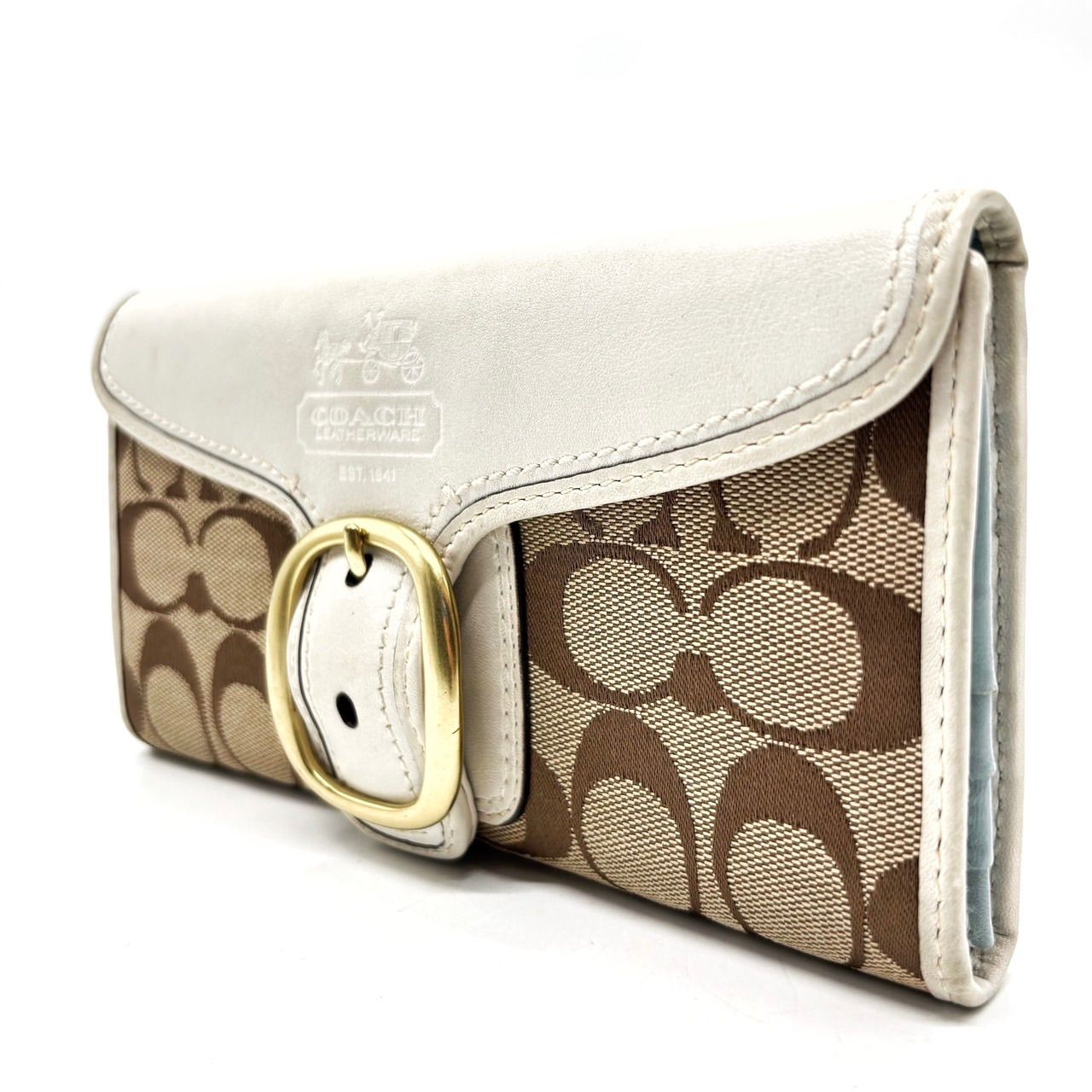 Beige canvas and white leather Coach compact wallet with a front gold-tone buckle.