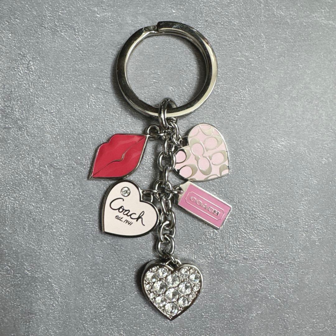 Photo of the y2k Coach key holder key ring showing multiple heart and lip charms attached to a metal ring.