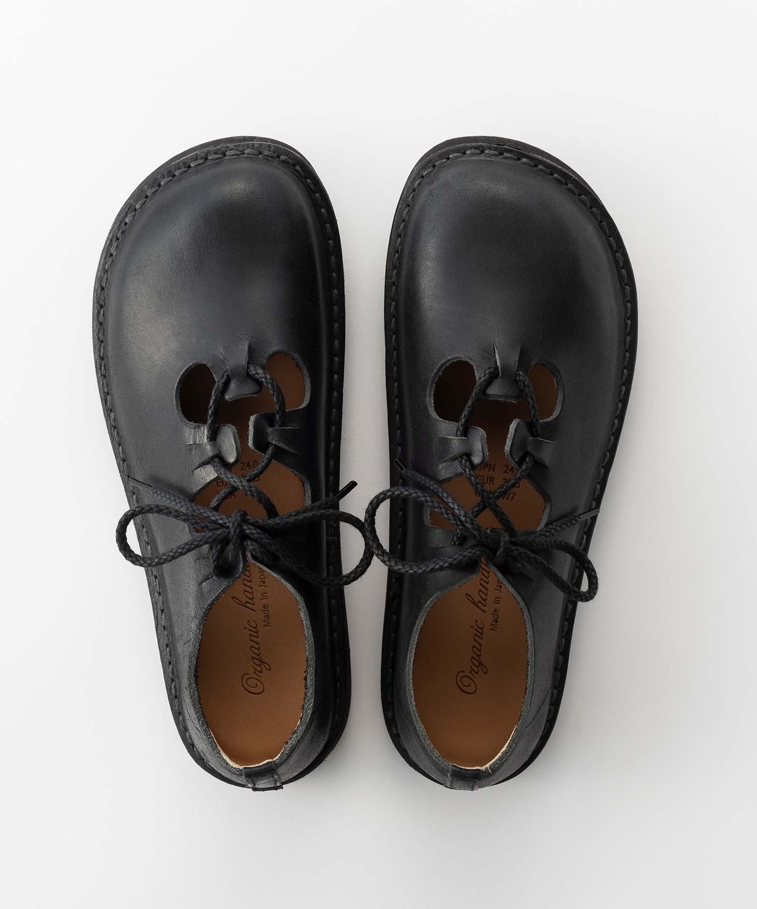Top-down view of a pair of black leather COALPORT shoes with lace-up cutout detailing on a white background.