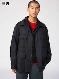 Male model wearing a black coated relaxed shirt jacket (men's polyester) shown from the front.