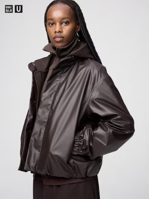 Woman modeling a women's coated short blouson polyester jacket in dark brown with a high collar and elasticated hem.