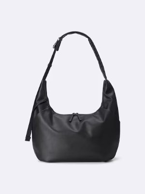 Front view of a black cocoon shoulder bag with a curved top and single shoulder strap made of polyester.