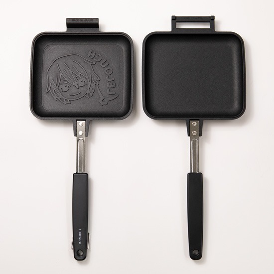 Open Code Geass hot sandwich maker showing an embossed character design on one cooking plate and a plain cooking surface on the other.