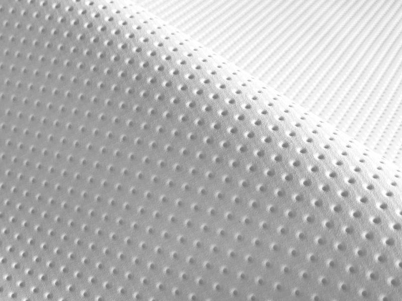 Close-up of white perforated synthetic leather fabric showing small dot-punch texture.