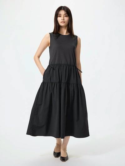 Front view of a model wearing a sleeveless combination tiered women's cotton dress in black.