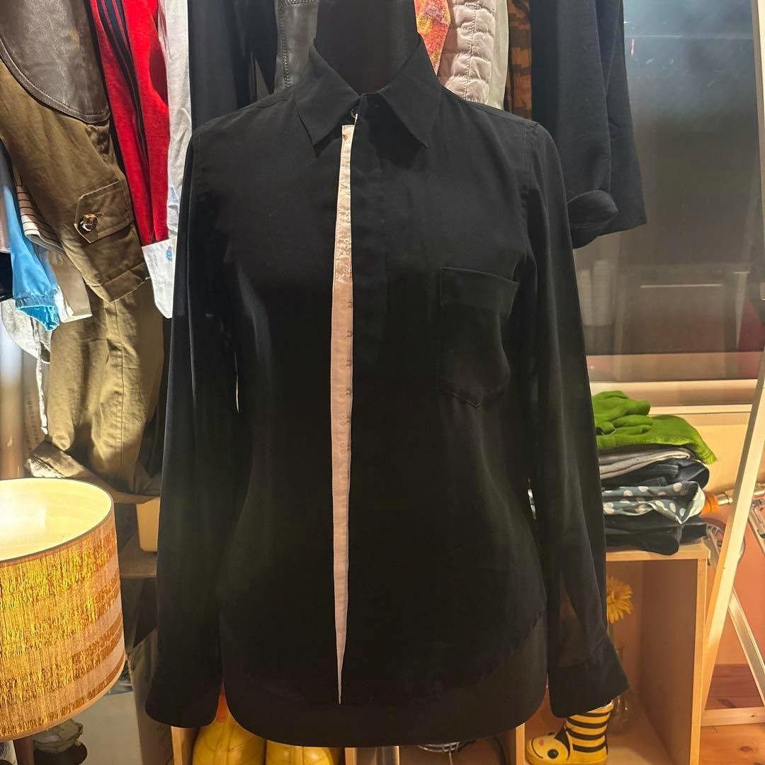Front view of the Comme des Garçons 04AW black sheer shirt on a mannequin showing a white center placket and a chest pocket.