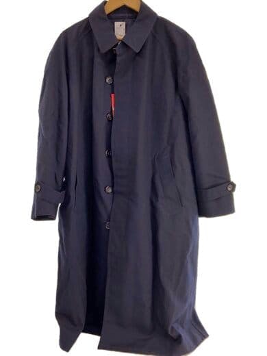 Front view of a dark long COMME des GARCONS HOMME DEUX coat hanging on a wooden hanger.