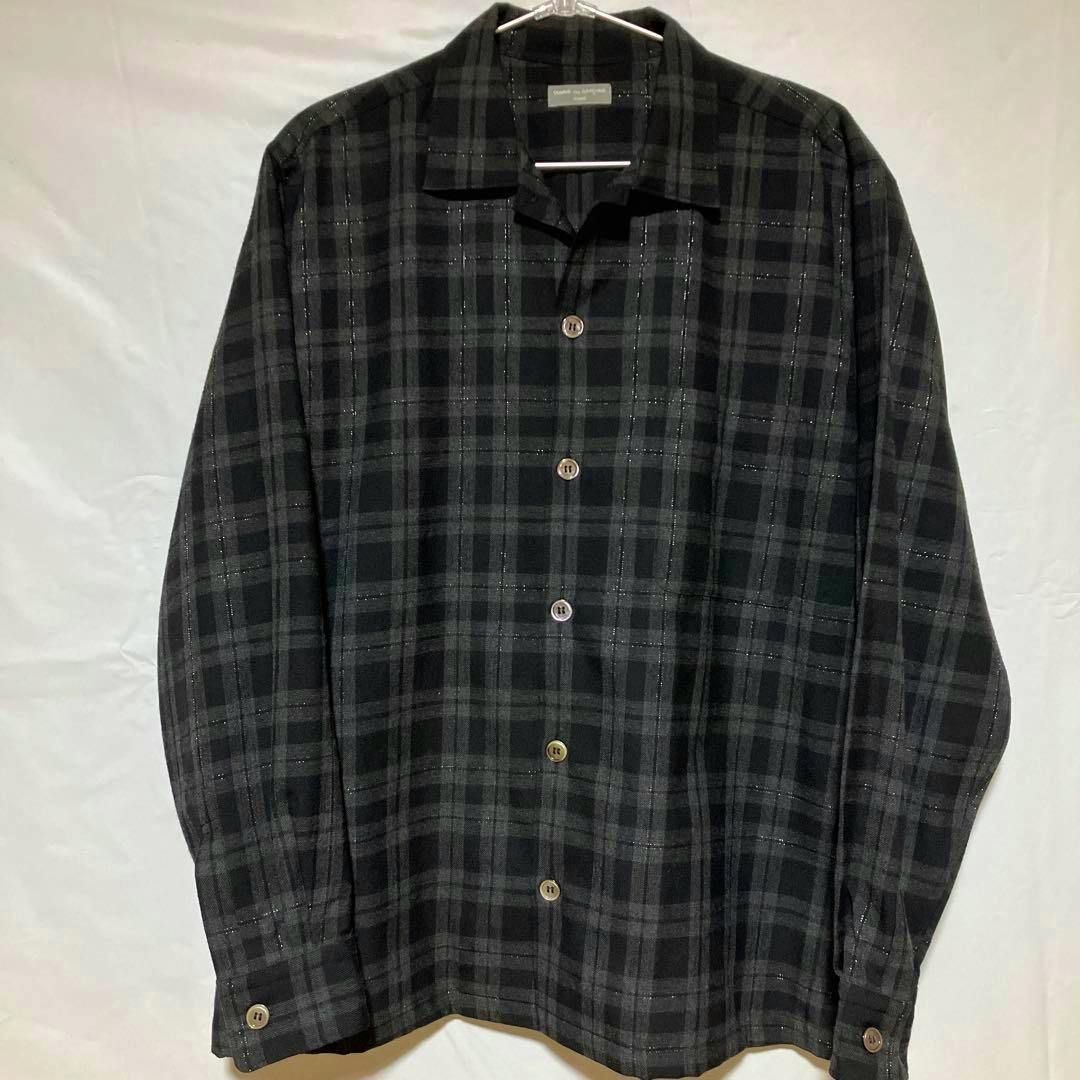 Front view of a COMME des GARCONS HOMME long-sleeve check patterned shirt hanging on a hanger.