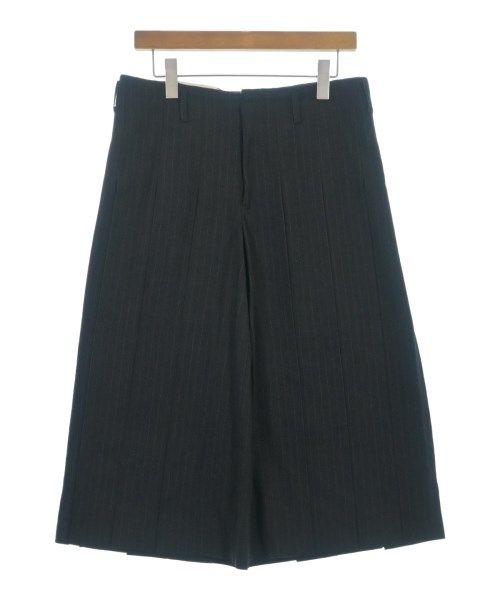 COMME des GARCONS HOMME PLUS cropped pants hanging on a wooden hanger against a white background.