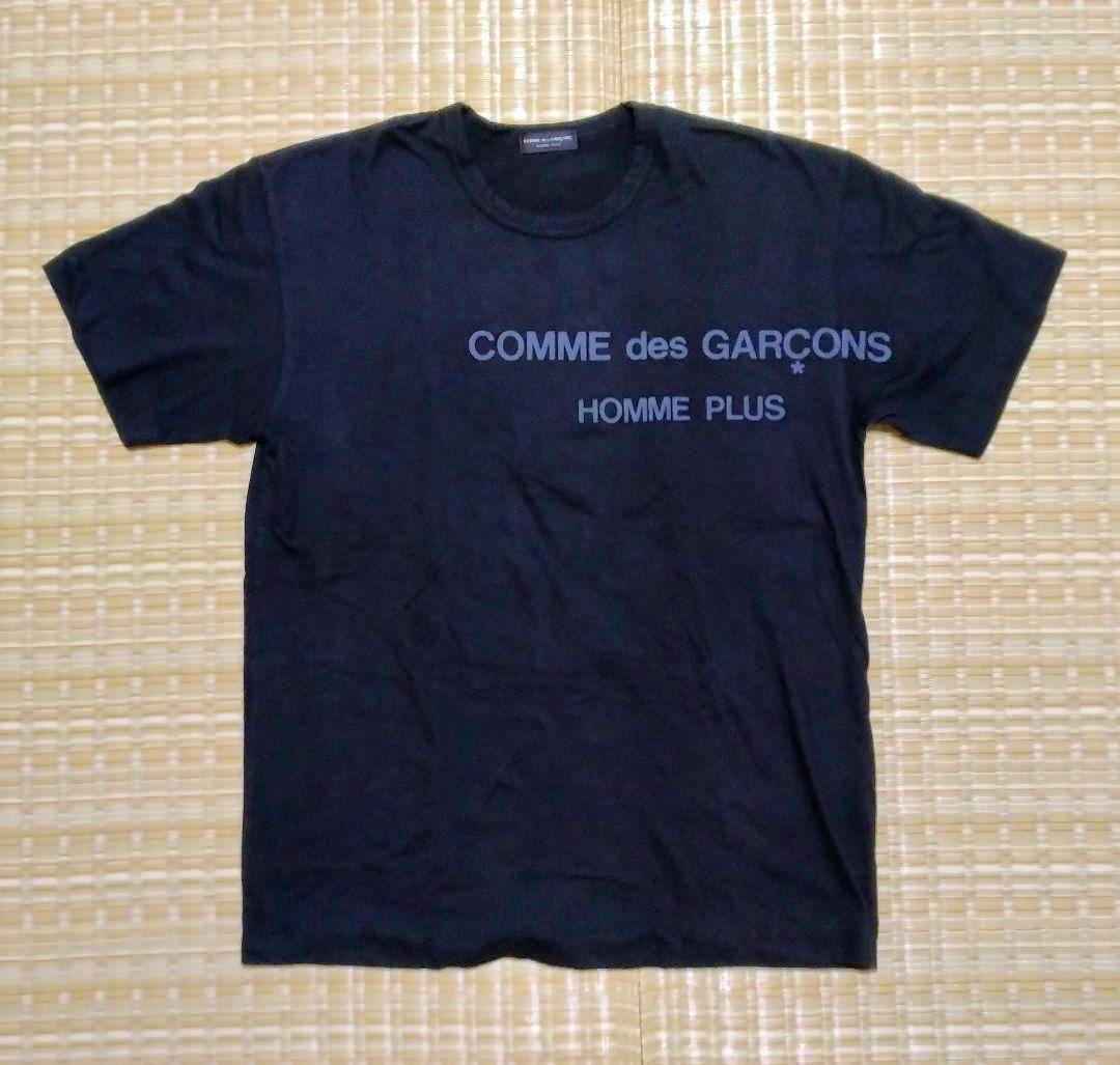 Black COMME des GARÇONS HOMME PLUS T-shirt laid flat showing the front logo.