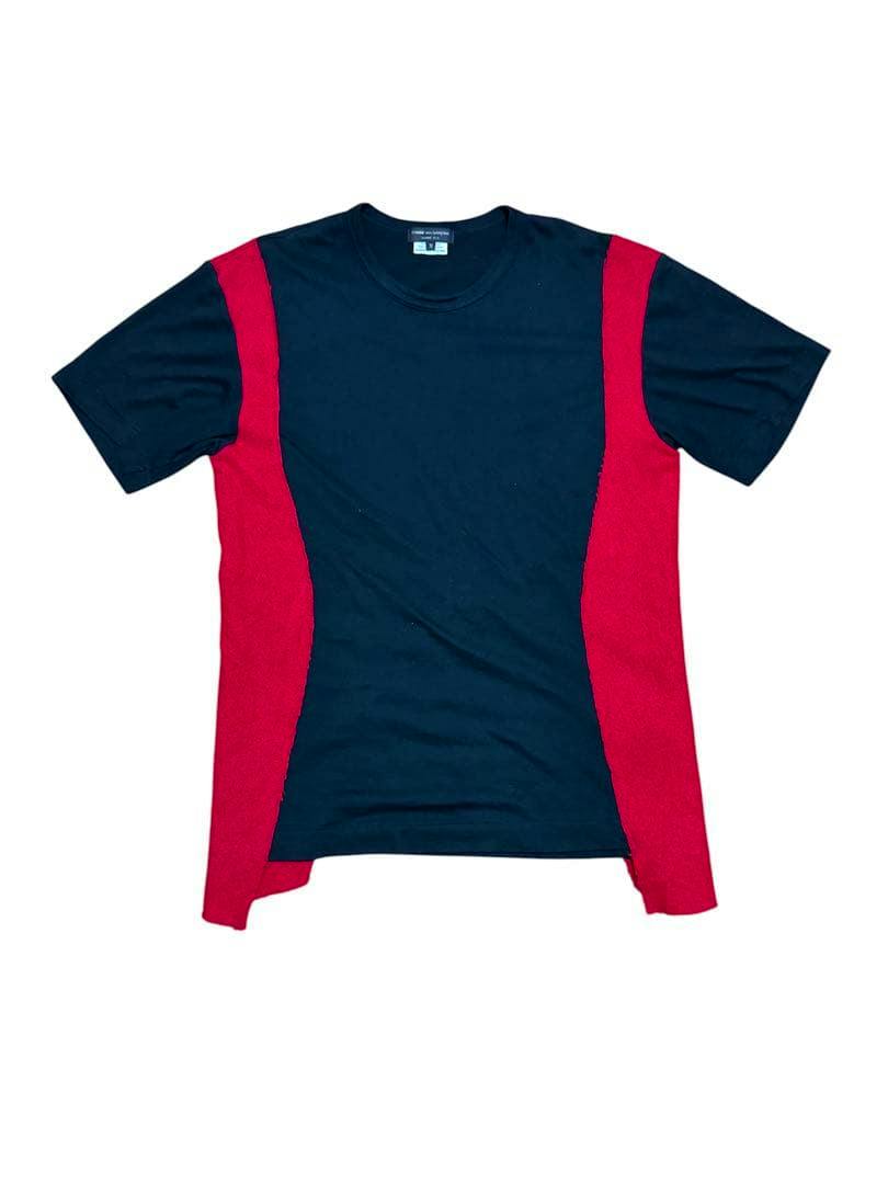 Flat-lay photo of the COMME des GARCONS HOMME PLUS Tシャツ showing a navy T-shirt with red side panels on a white background.