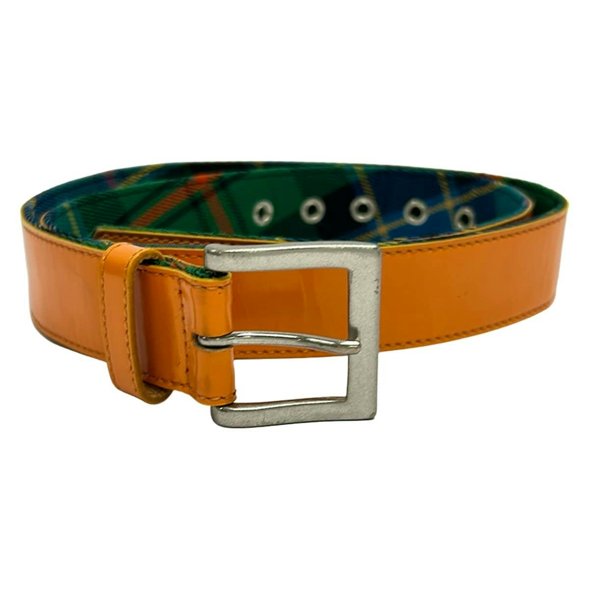 Orange leather belt with a silver square buckle and green plaid inner lining.