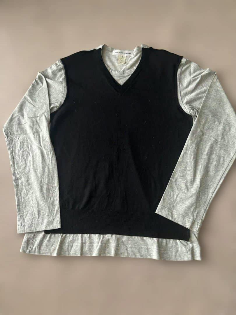 Flat-lay front view of the men's COMME des GARCONS V-neck cotton shirt with a black V-neck overlay and grey long sleeves.