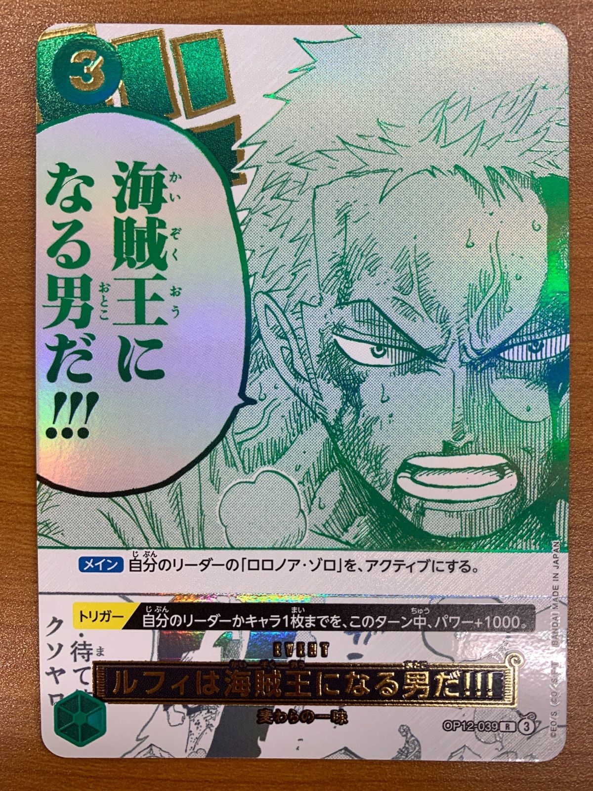 Photo of the One Piece trading card showing Roronoa Zoro artwork, Japanese text, and holographic holographic foil.