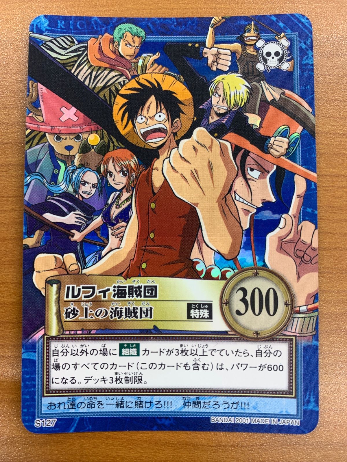 Front of a One Piece trading card showing Luffy and other Straw Hat Pirates, a circular "300" power icon, and Japanese text.