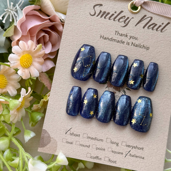 Set of blue constellation-themed nail tips with gold star stickers displayed on a Smiley Nail card.