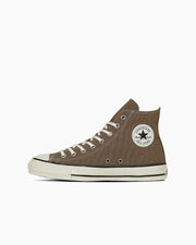 Side view of a brown aged high-top canvas sneaker with white rubber sole and round ankle patch.
