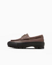 Side profile of a brown synthetic leather oxford-style shoe with a chunky black lug sole.
