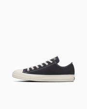Side view of a black canvas low-top sneaker on a white background.