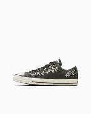 Side profile photo of a black All Star Folkstitch OX low-top canvas sneaker on a white background.