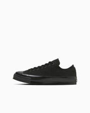 Black low-top canvas sneaker shown in side profile on a white background.