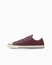 Side view of a maroon canvas low-top sneaker on a white background.