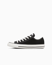 Side view of a black canvas low-top All Star OX sneaker on a white background.