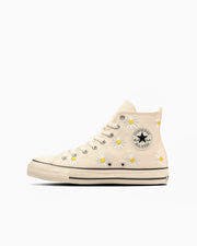 Side profile of an All Star Daisyflower high-top canvas sneaker in beige with daisy print and a round ankle logo patch on a white background.