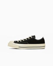 Black canvas low-top sneaker with a square toe shown in side profile on a white background.