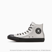 Side view of a white leather All Star high-top sneaker with a black toe cap, black sole, and circular star ankle patch.
