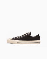 Side view of a black canvas low-top sneaker (ALL STAR US OX) on a white background.