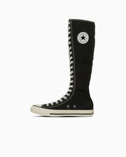 Black canvas high-top boot with white rubber sole and star logo on the ankle shown in profile on a white background.