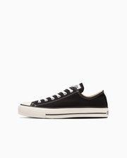 Side profile of a black canvas low-top sneaker on a white background.