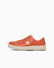 Side view of an orange leather sneaker with a white star on the side and a white sole.