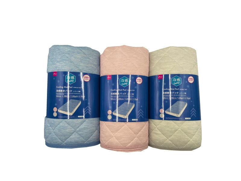 Three rolled cooling mattress pads (melange style) in blue, pink, and beige with product labels visible.
