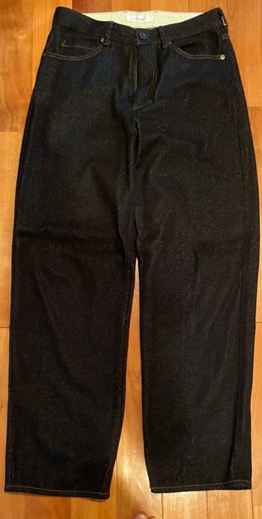 Dark navy silk-nep denim pants laid flat showing the front view of the trousers.