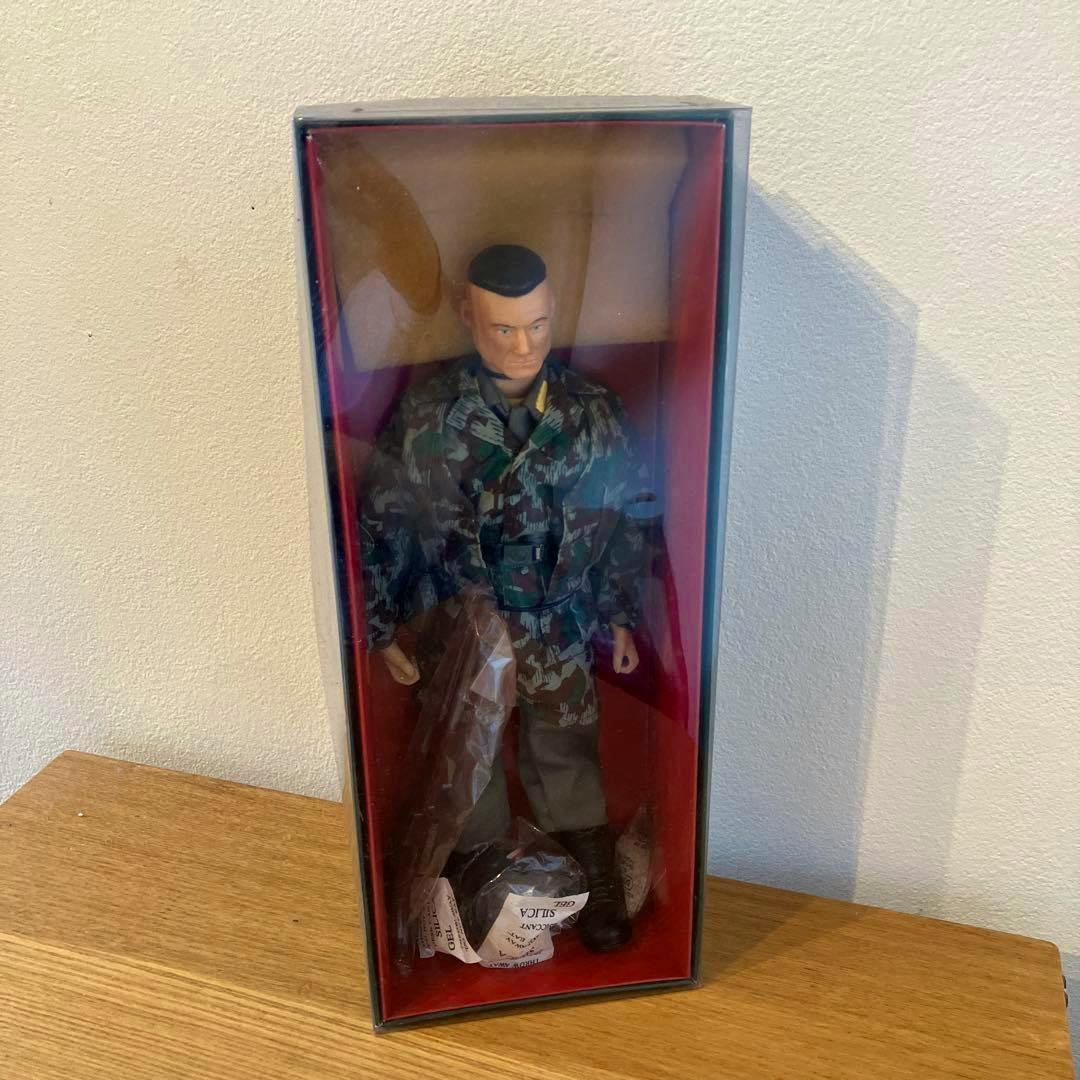 Boxed 3F Cotswold Elite Brigade paratrooper plastic figure in camouflage uniform visible through a clear-front display box.