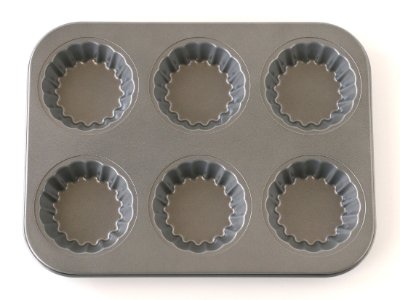 Top-down photo of a six-cavity fluted tart pan (stainless steel) on a white background.