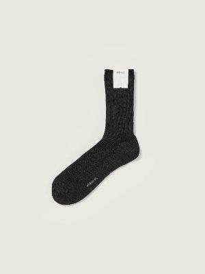 A single dark knit low-gauge sock laid flat on a light background with a white tag at the cuff.