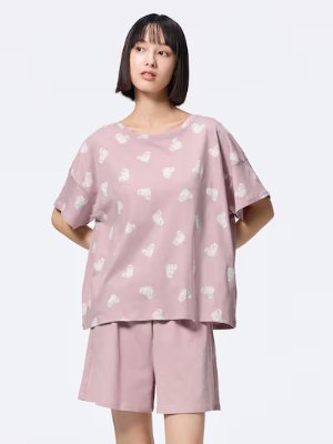 Model wearing a pink cotton women's short-sleeve lounge set with a white cat print.