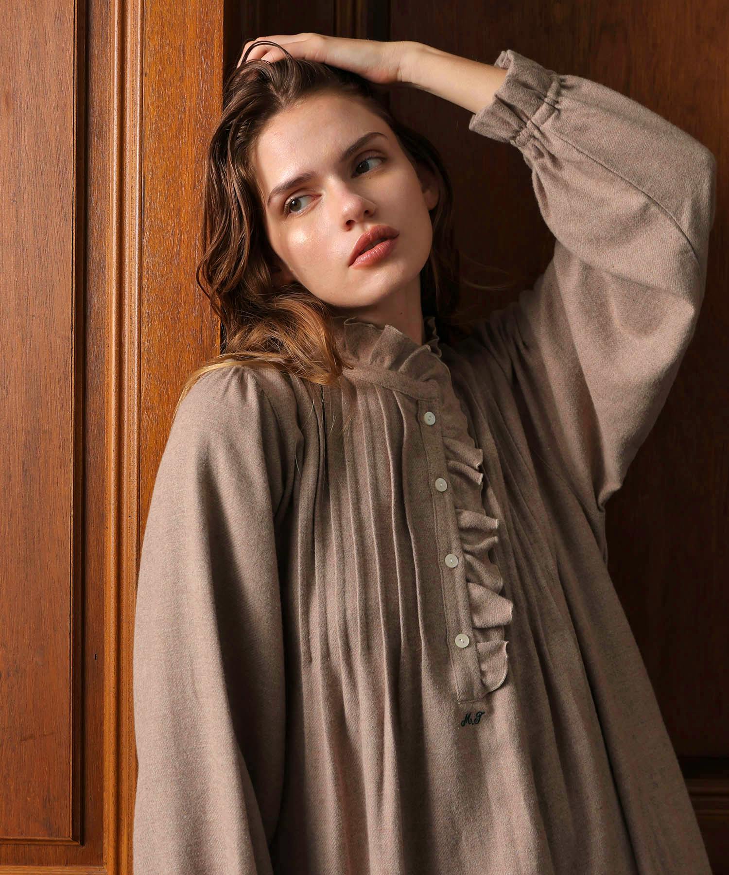 Close-up of a model wearing the cotton flannel frill dress, showing pleated front, ruffles, buttons and long sleeves.